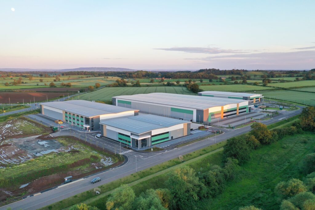 Aerial view of a commercial warehouse complex in the countryside at sunset