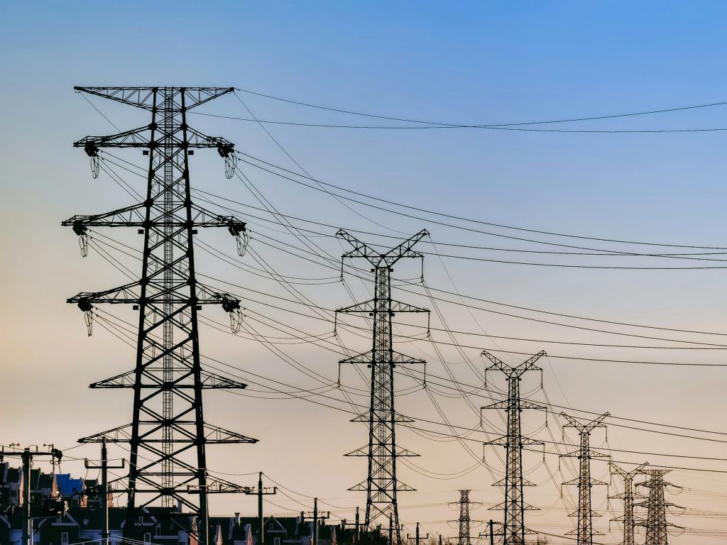 Transmission towers silhouetted against a dusk sky