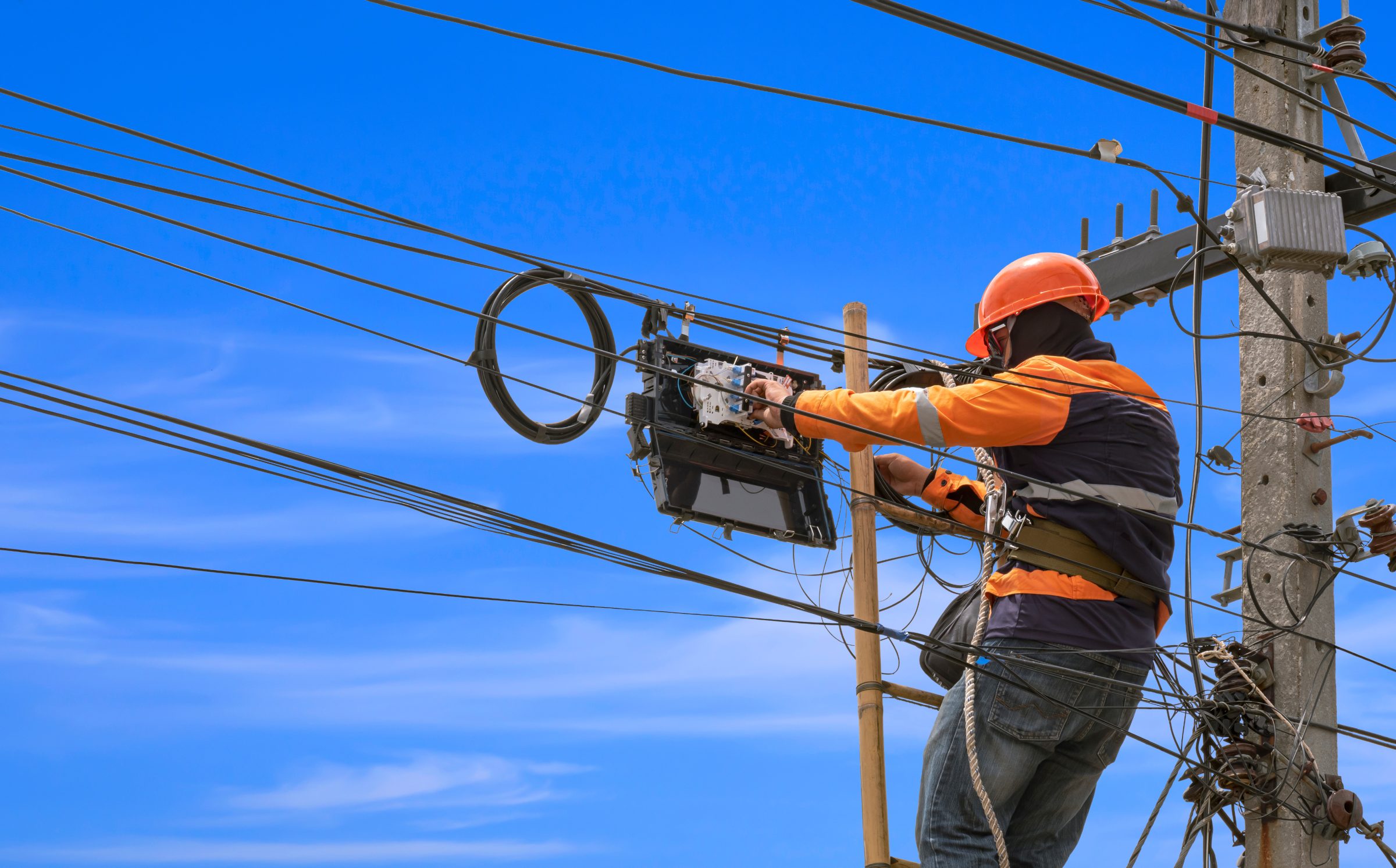 Lineworker in a bucket handling telecommunications cable