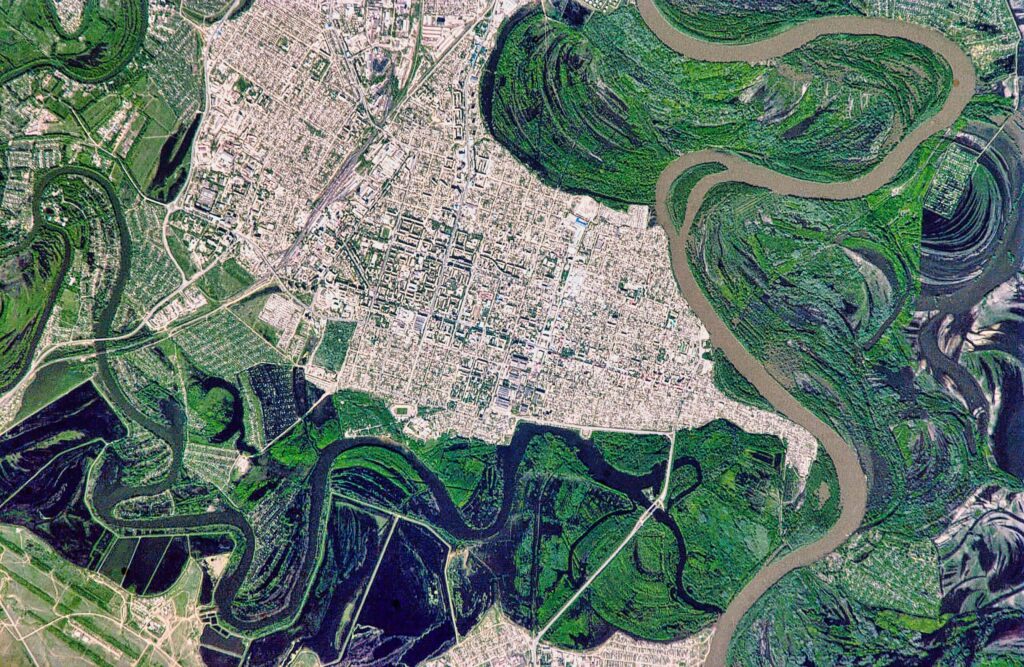 Satellite view of a city bordered by winding rivers and floodplain